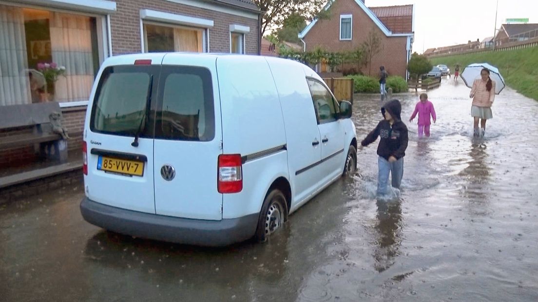 Wateroverlast na hoosbui in Yerseke - kinderen in volgelopen straat