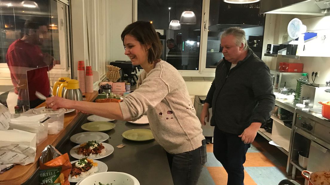Vrijwilligers Eline en Patrick serveren de chili.