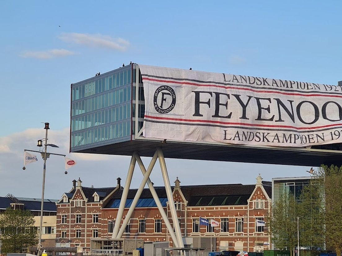 Het Feyenoordspandoek hangt bijna volledig om het oud Unilever-gebouw heen