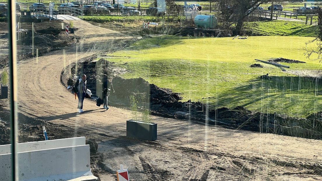 Golfers komen een balletje slaan. De weg ligt er nog niet in.