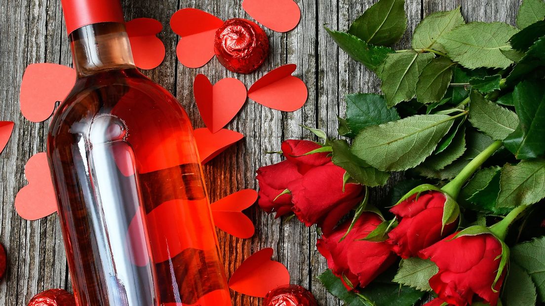 Een flesje rood en bloemen voor Valentijnsdag