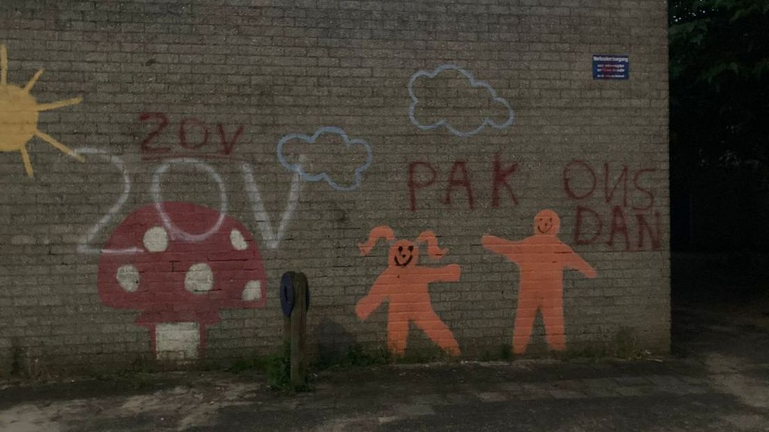 De tekst 'Pak ons dan' op de muur van de basisschool in de wijk