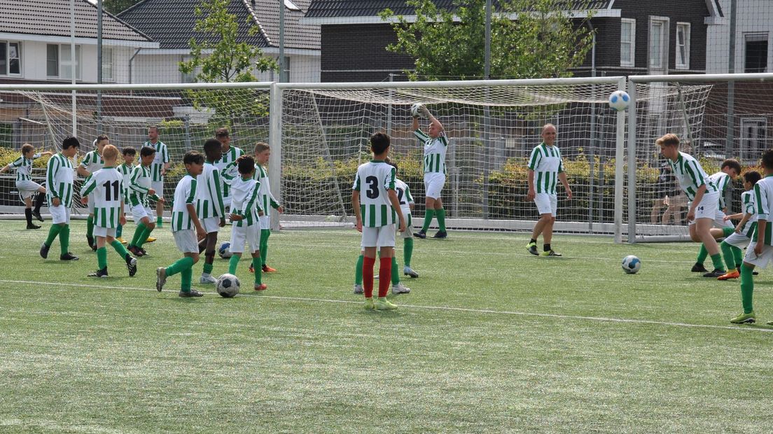 Jeugdspelers van Victoria'28 voetballen tegen spelers van het eerste elftal tijdens de Dag van Victoria