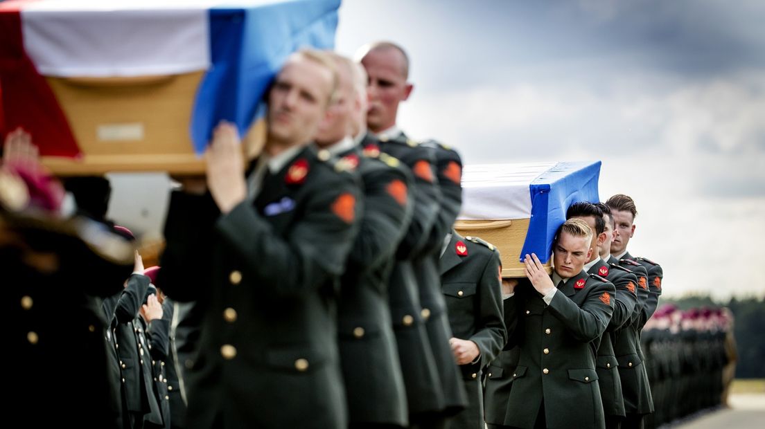 Militairen dragen de kisten met de lichamen van de omgekomen militairen