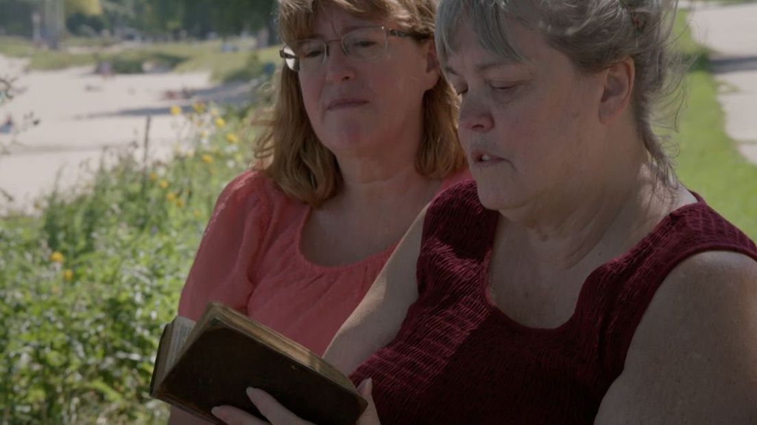 Rebecca Foster Wilson (links) en haar zus Rebecca Foster Wilson koesteren het psalmenboekje van hun voorouders, dat aanspoelde na de ramp met de Phoenix.