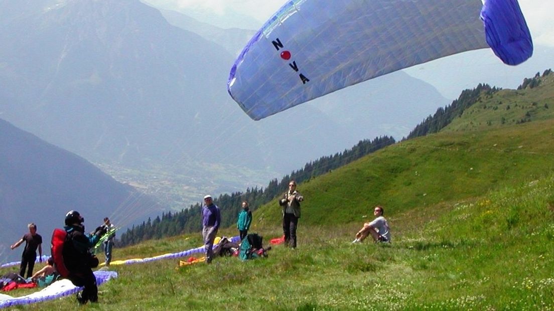 Paraglider stijgt op met parapente vanaf bergtop