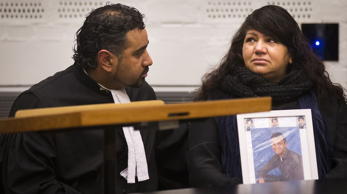 De moeder van Rishi Chandrikasing in de rechtbank met een foto van haar zoon