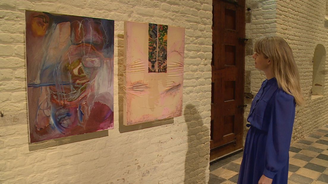 Directeur Roos Gortzak bekijkt twee schilderijen in de expositieruimte de Vleeshal.