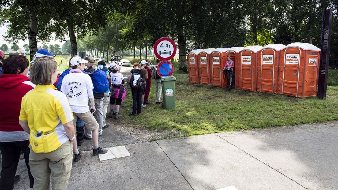 Vierdaagsewandelaars in de rij voor toiletten