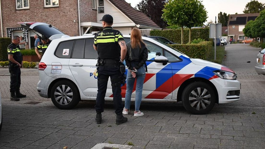 Een van de verdachten wordt geboeid afgevoerd