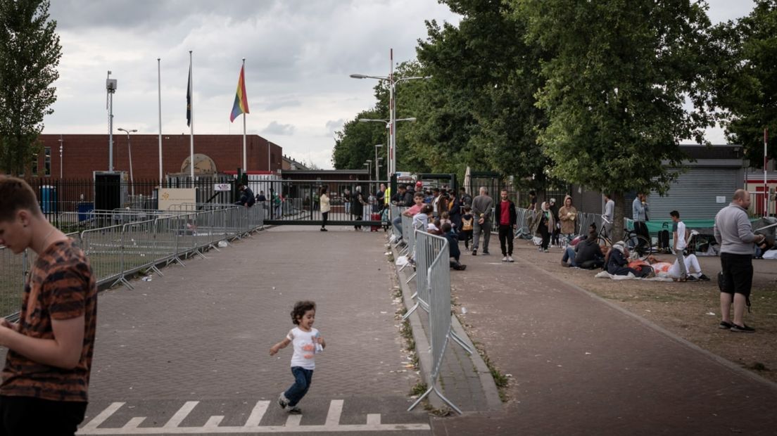 Een kind speelt voor de poort van het aanmeldcentrum in Ter Apel