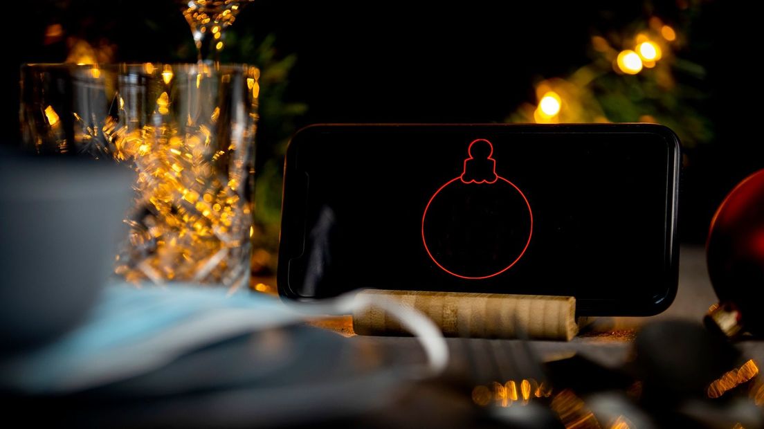 Met mobiel op tafel voor de kerstborrel