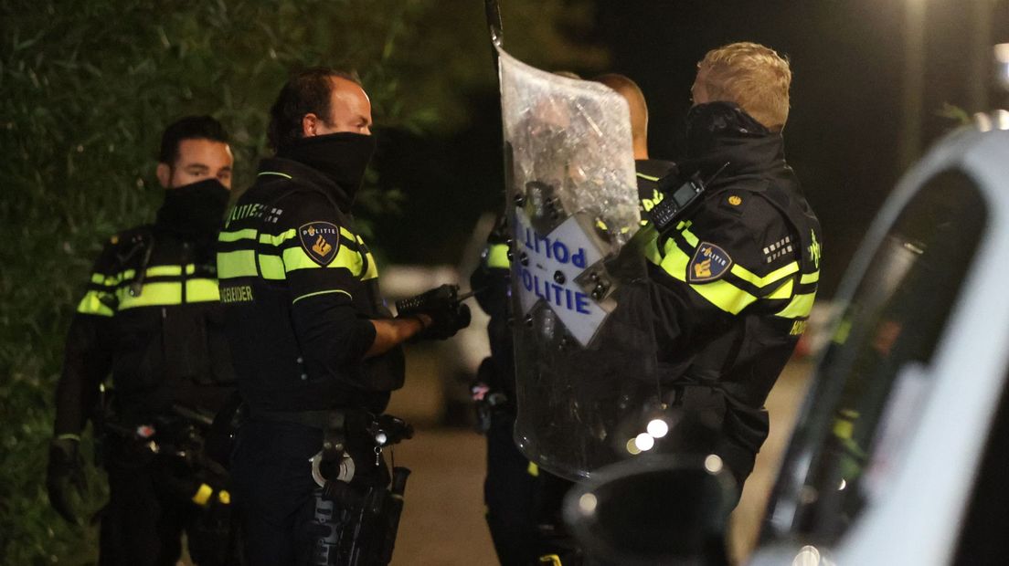 Politieagenten met schilden gaan een huis in Den Haag binnen na een melding-steekpartij