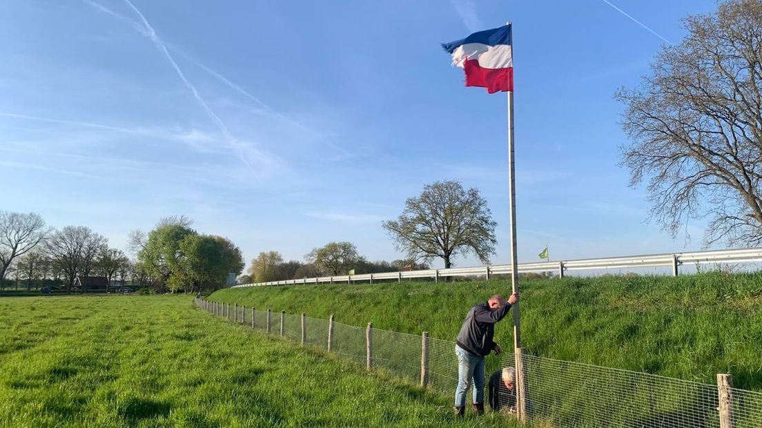 Han en Gert-Jan halen de vlaggen naar beneden langs de N36 bij Diffelen