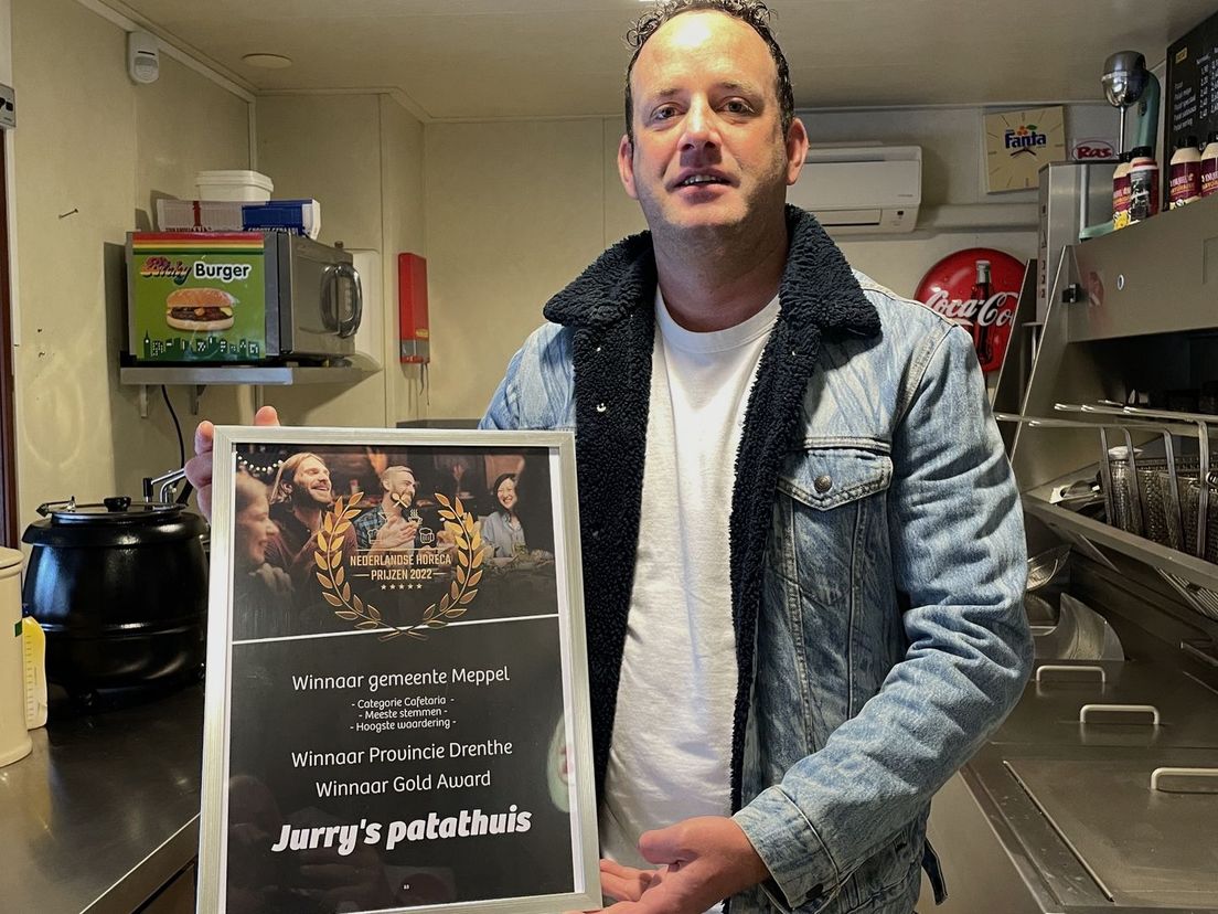 Jurry Frank met zijn oorkonde in zijn cafetaria Jurry's Patathuis