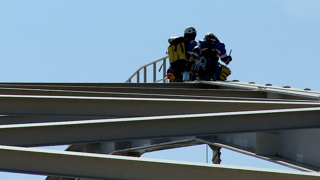 Specialisten van het rope-team aan het werk, hoog op de brug.