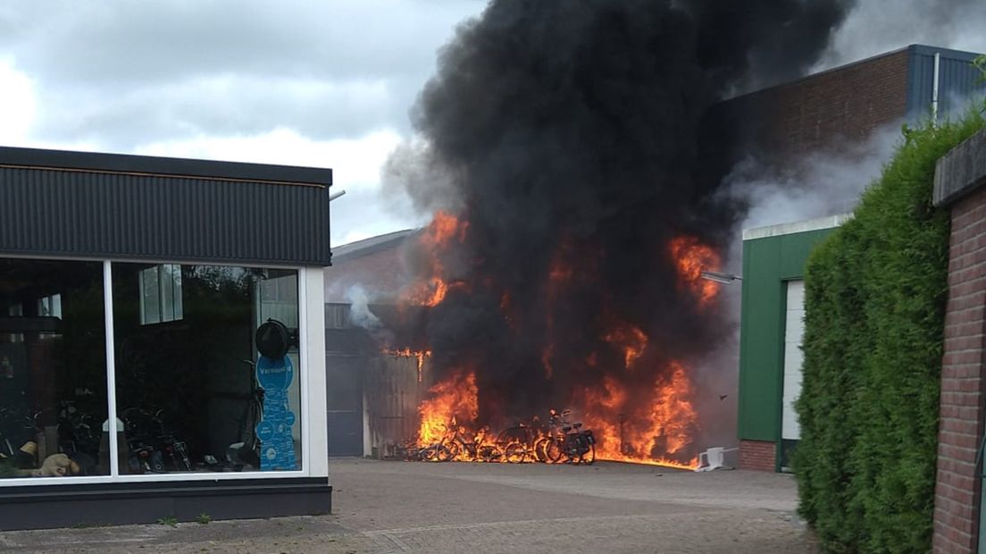 Vlammen en zwarte rook bij de werkplaats