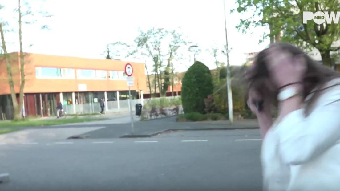 Screenshot YouTube. Verslaggeefster PowNed duikt weg na stenenregen