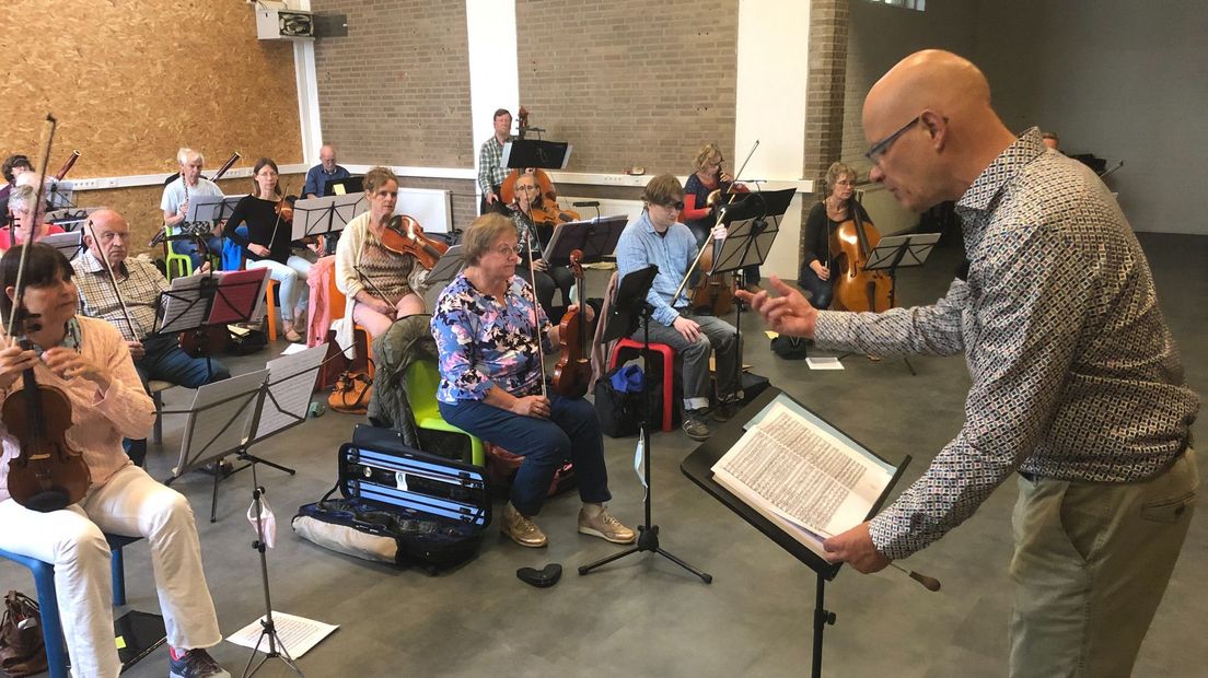 Dirigent Martin van der Brugge repeteert met muzikanten