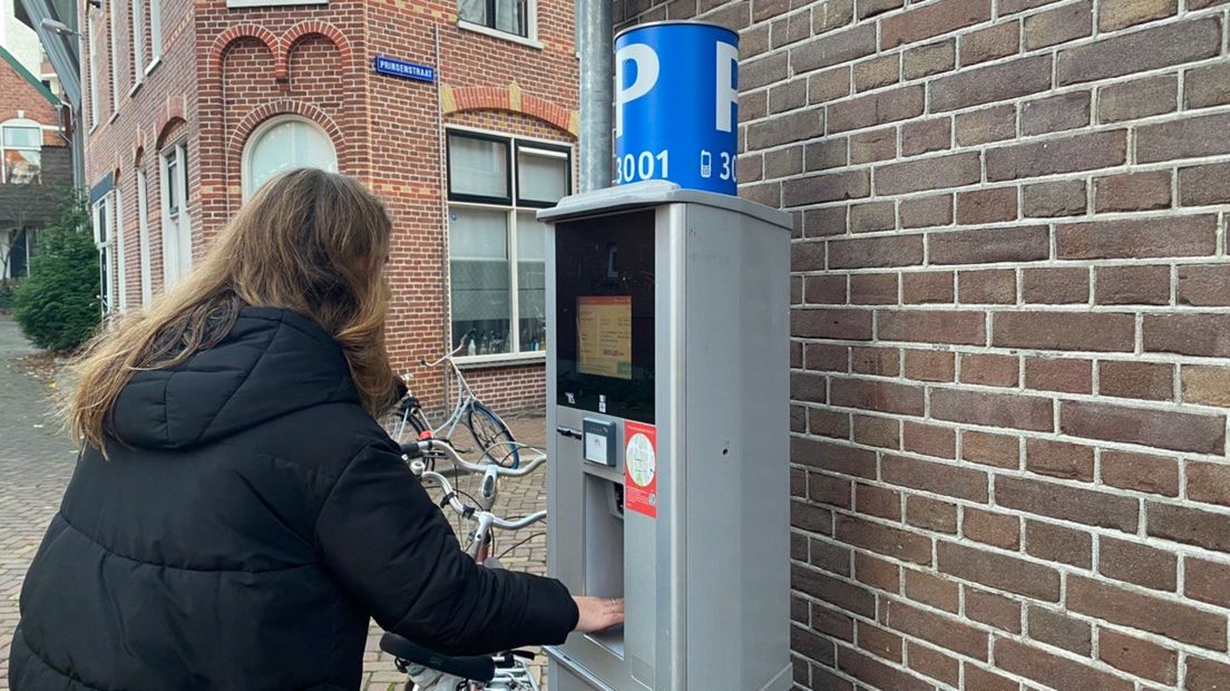 Een vrouw bij een parkeerautomaat aan de Prinsenstraat in het stadscentrum van Groningen