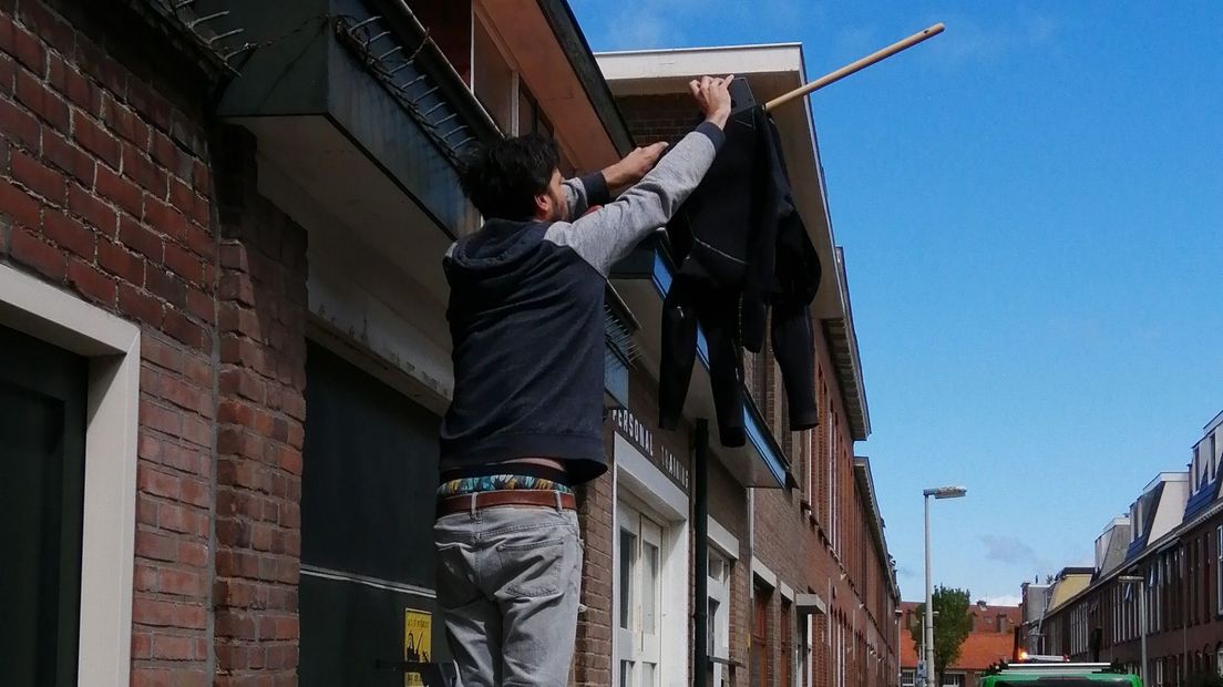 Een surfpak wordt aan een vlaggenmast gehangen vanwege de omgekomen watersporters. I
