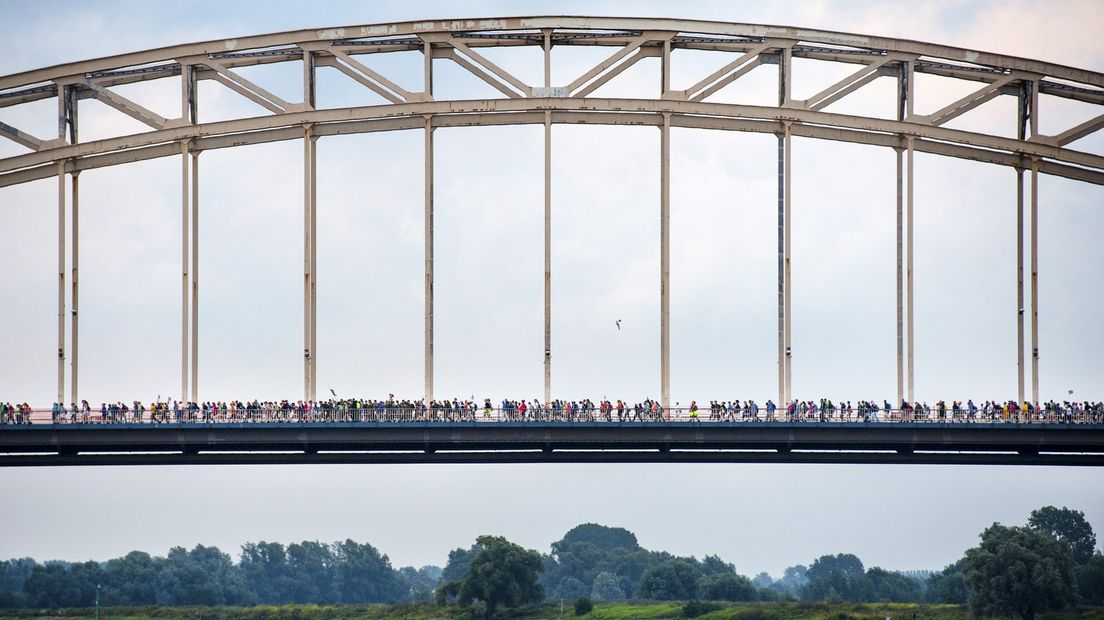 Deelnemers wandelen over de Waalbrug op de eerste dag van de 99ste editie van de Vierdaagse.