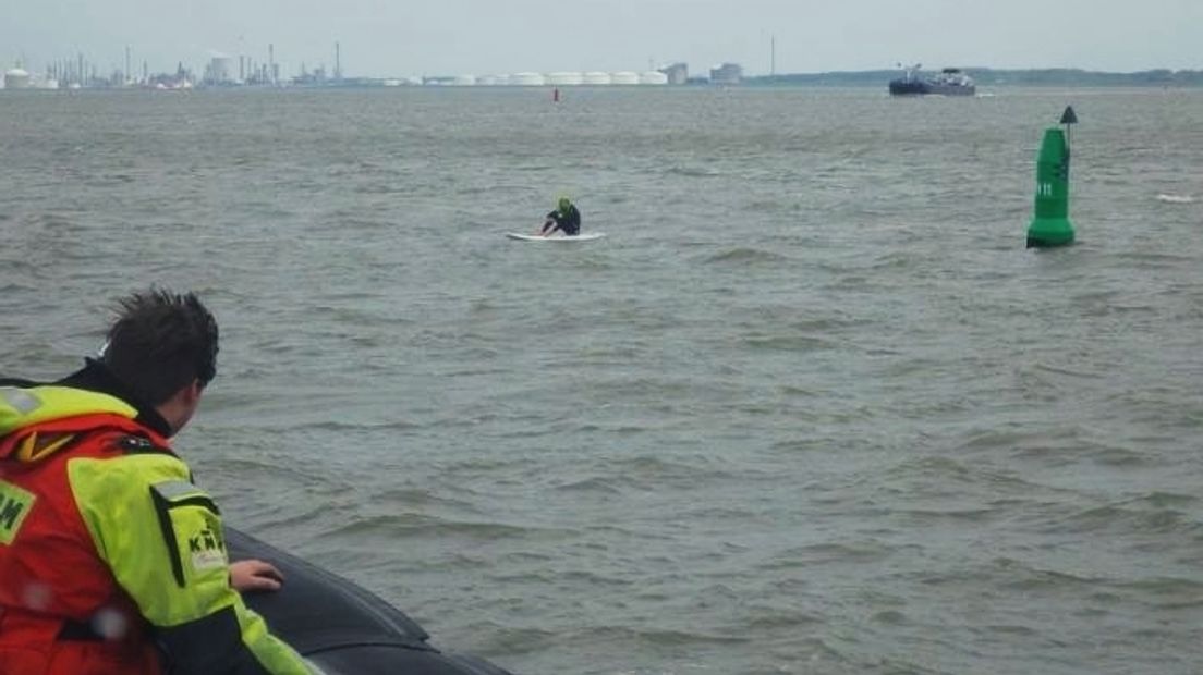 Uitgeputte windsurfer klampt zich vast aan boei in Westerschelde
