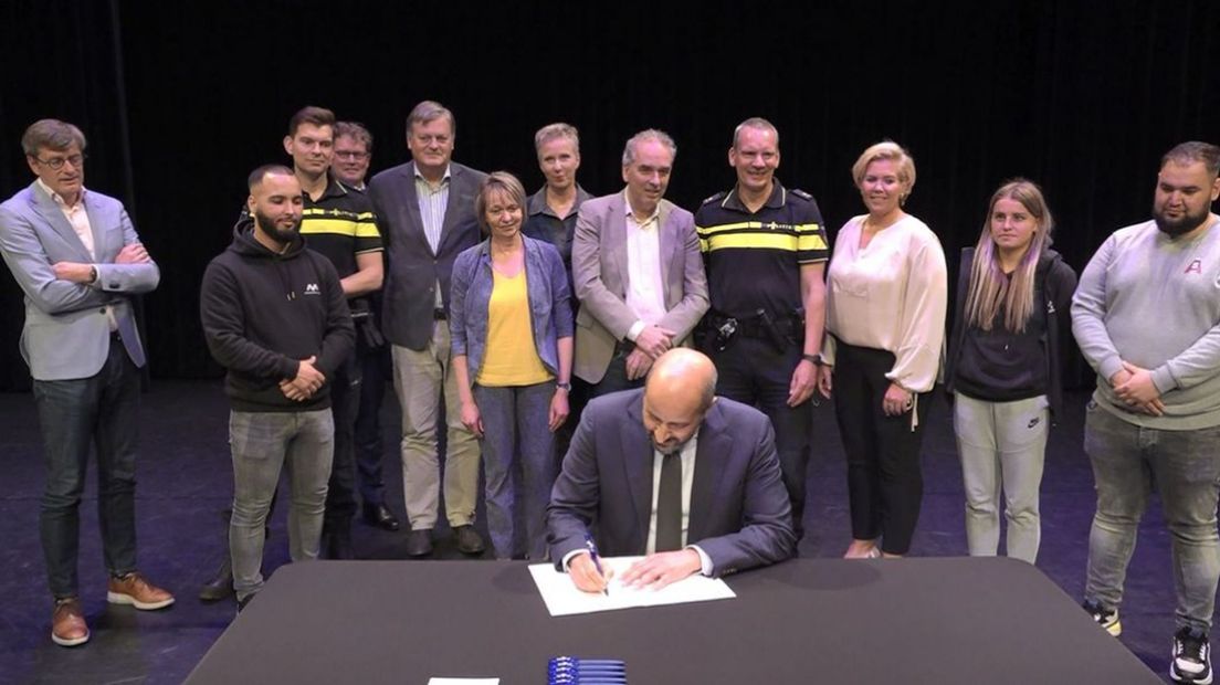 Burgemeester Ahmed Marcouch tekent als eerste de samenwerkingsovereenkomst.