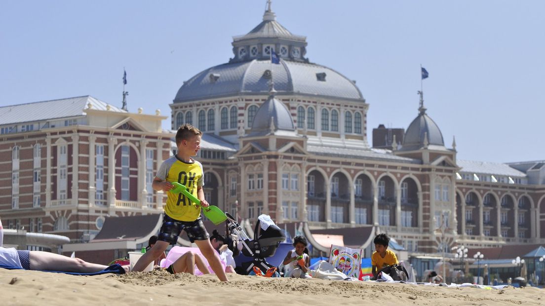 Een jongetje op het strand van Scheveningen met op de achtergrond het Kurhaus