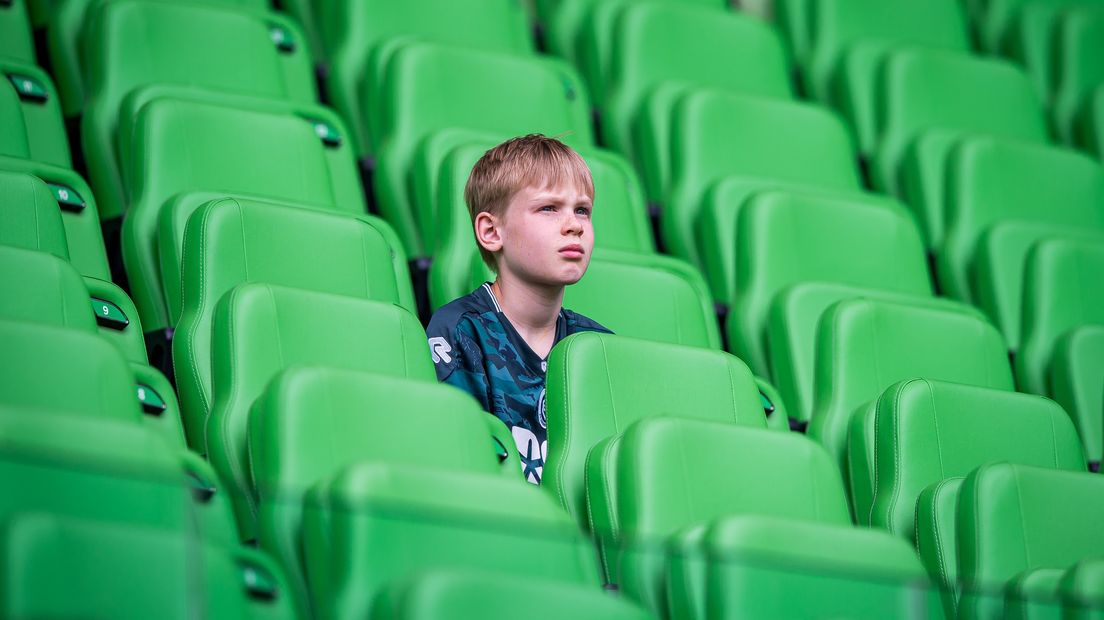 Een jonge FC-fan teleurgesteld op de tribune, na het staken van de wedstrijd