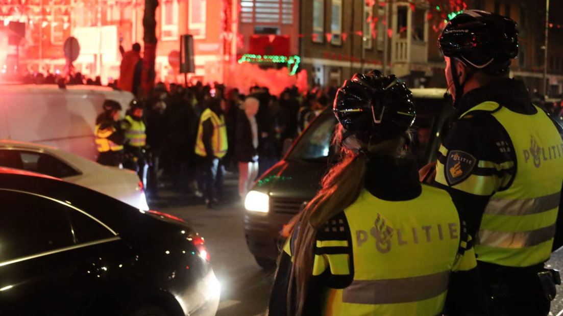 Agenten houden toezicht bij het overwinningsfeest in de Haagse Schilderswijk