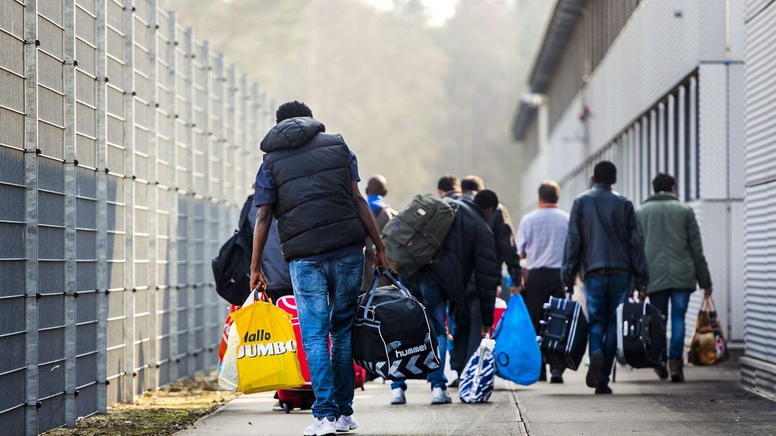 Asielzoekers arriveren een asielzoekerscentrum in Nederland
