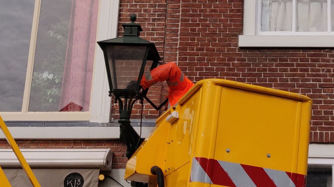 De nieuwe straatverlichting op de Dunne Bierkade in Den Haag wordt opgehangen. | Foto Omroep West