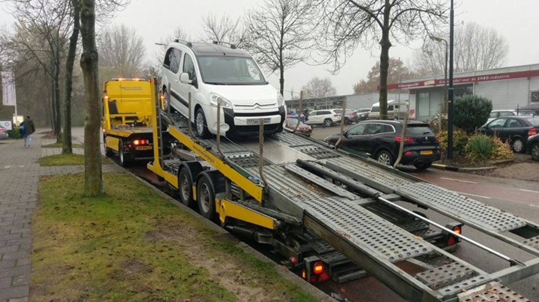 Een auto wordt weggehaald bij een van de autobedrijven