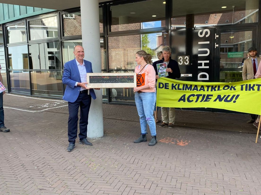 Wethouder Martin Rasker ontvangt de klimaatklok van Conny Darwinkel