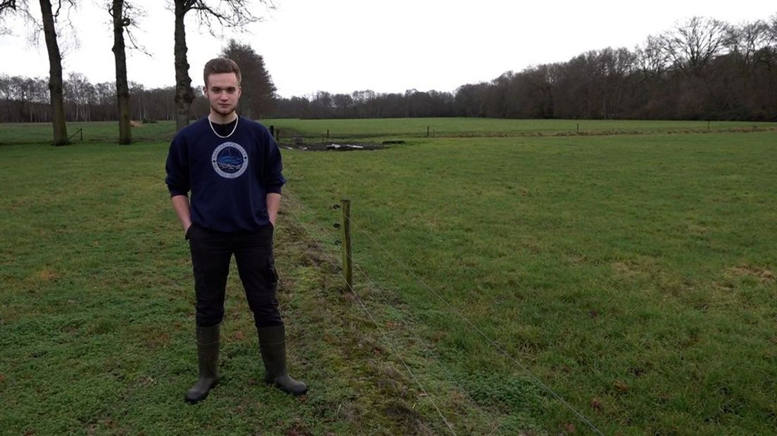 Steven in een lege wei waar normaal gesproken schapen zouden grazen.