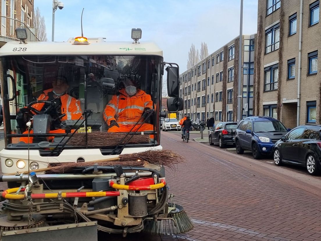 Straatvegers op de borstelwagen