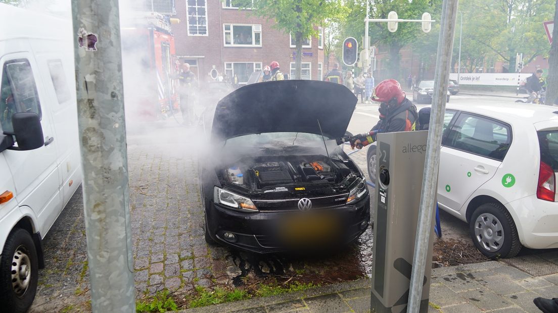 De brandweer blust de auto waarin brand was ontstaan