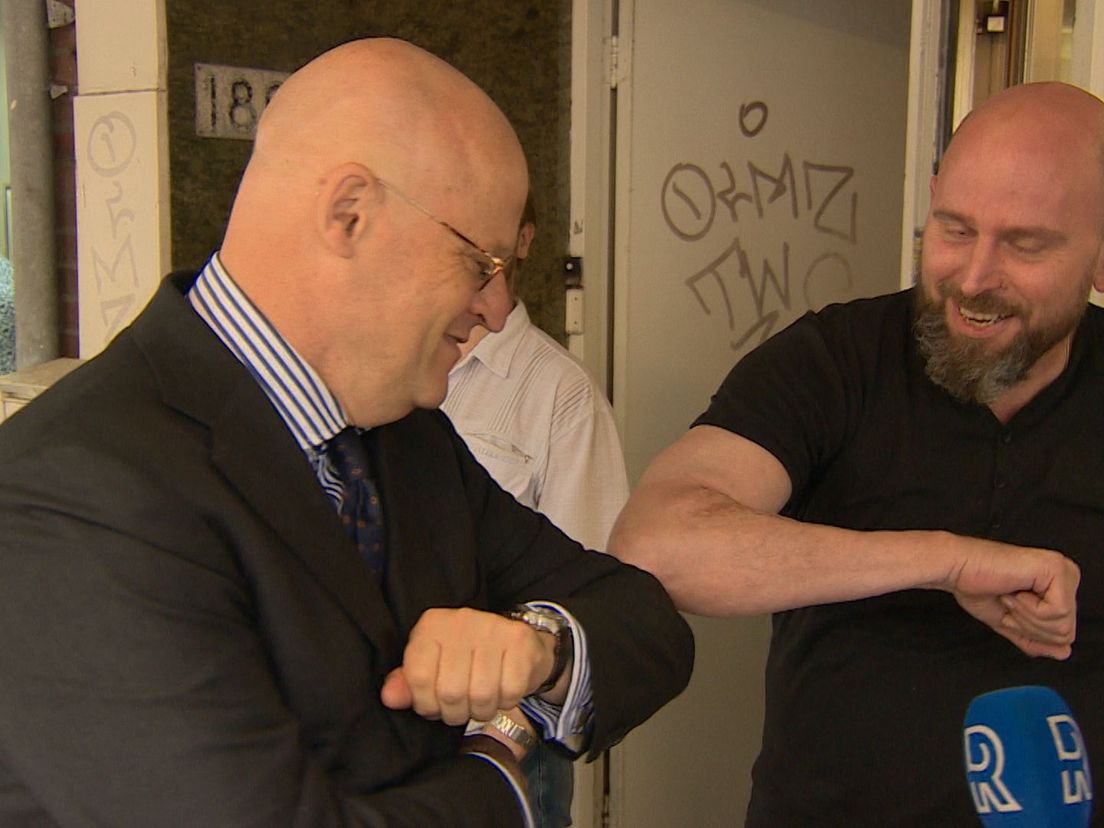 Minister Grapperhaus (L) geeft een ellebooggroet