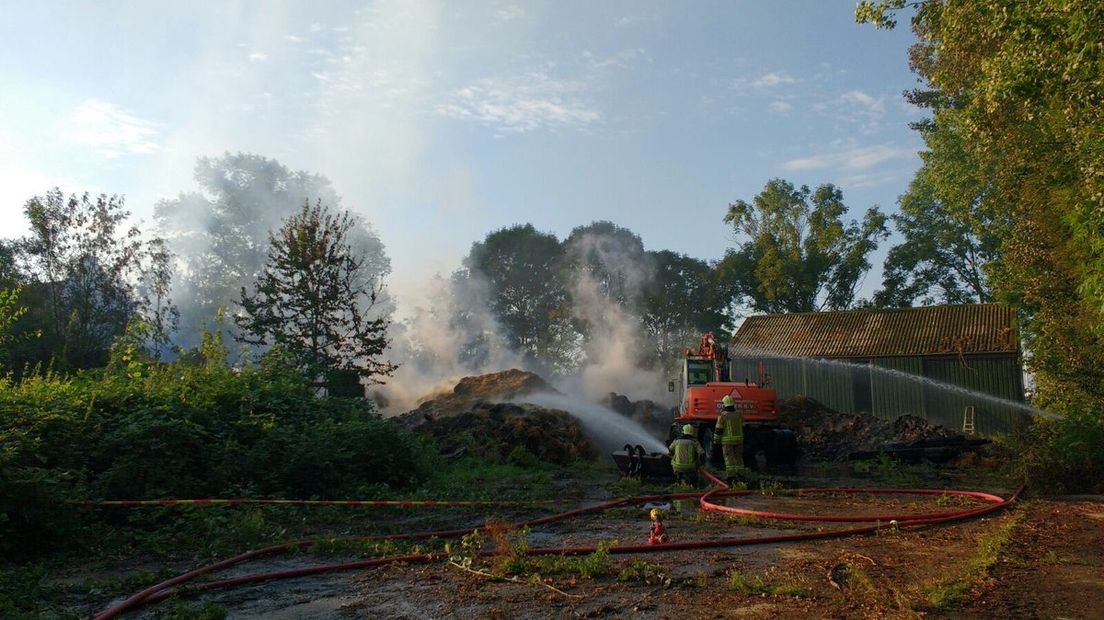 De brandweer is nog de hele ochtend bezig bij de uitgebrande hooischuur in Kapelle.