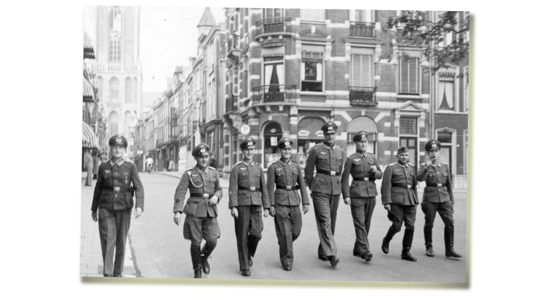 Duitse militairen wandelen op de Mariaplaats in Utrecht, op de achtergrond de Zadelstraat en de Domtoren.