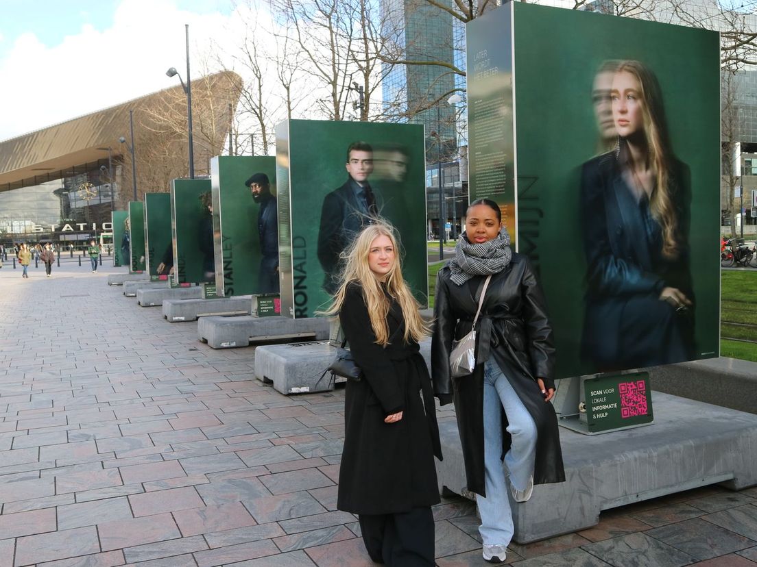 Annemijn (links) en Lincey (rechts) bij de portretfoto's van kinderen van ouders met psychische problemen
