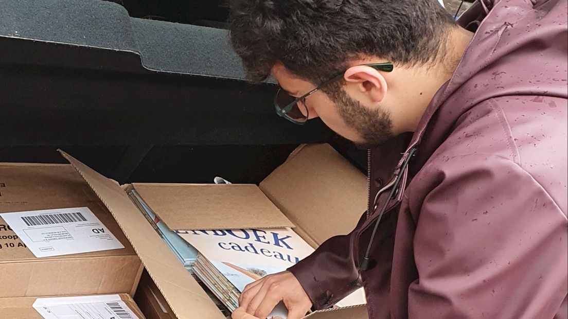 Raadslid Deniz Dönmez laadt dozen vol prentenboeken in zijn auto