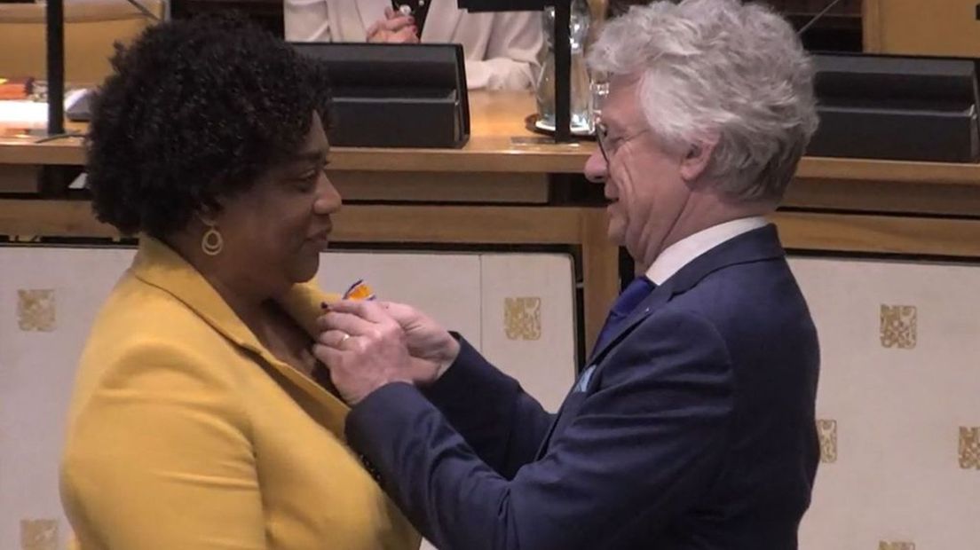 Marilyn A-Kum krijgt een lintje van John Berends.
