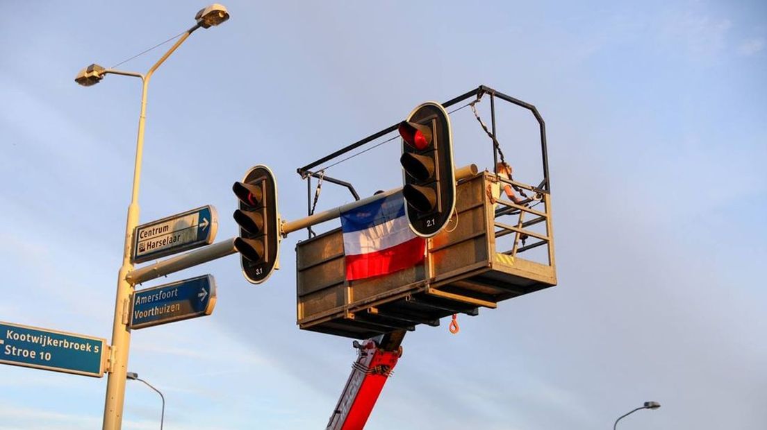Hier hangen boeren een vlag ondersteboven op in Barneveld.
