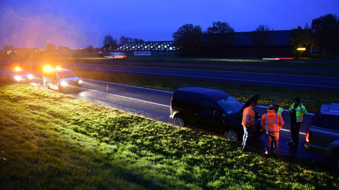 Hulpdiensten bij het busje, nadat de vlammen gedoofd zijn