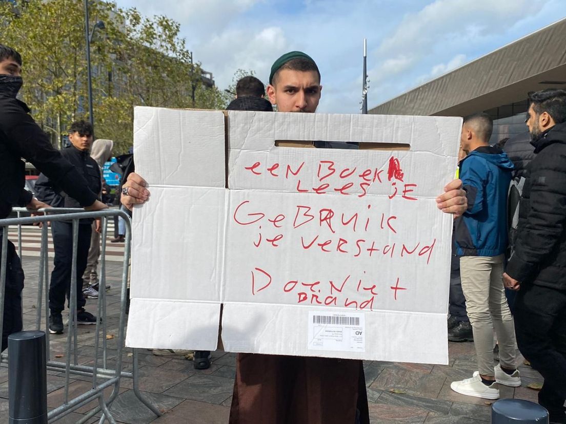 De tegendemonstranten hebben kartonnen borden met leuzen bij zich