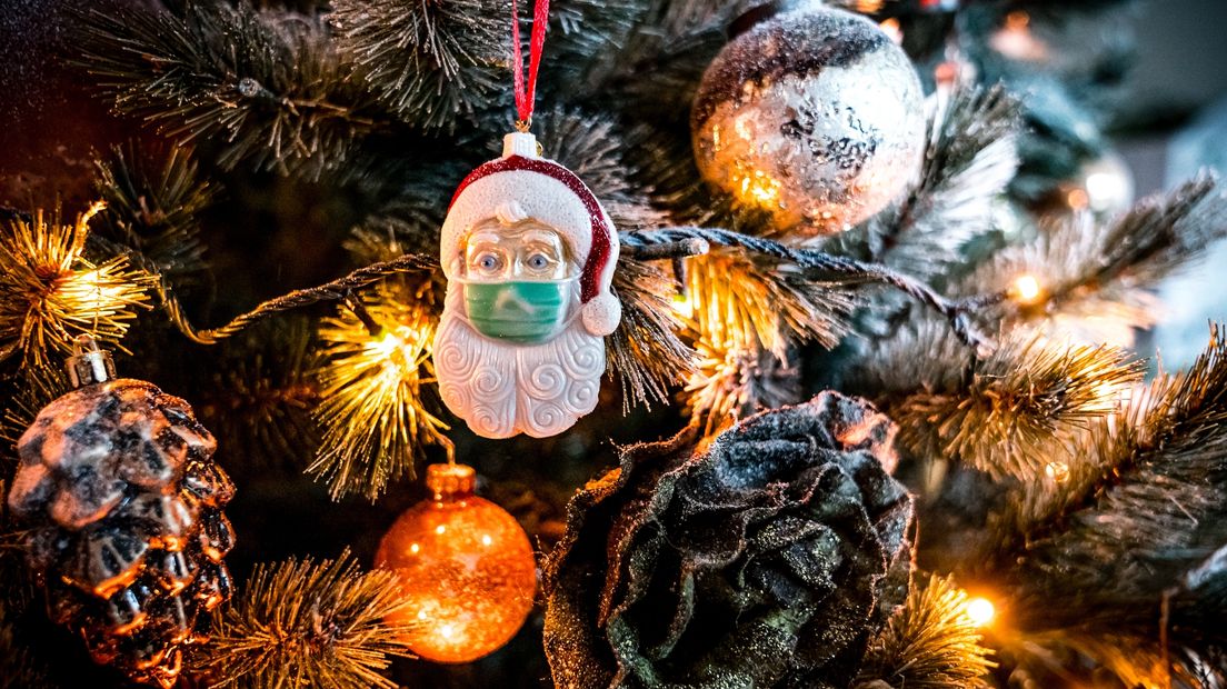 Een kerstman-kerstbal met mondkapje: ook dit jaar ontkomen we niet aan coronamaatregelen tijdens de kerstdagen