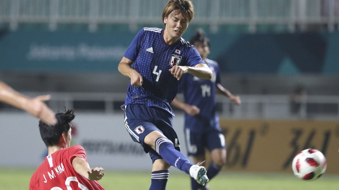 Ko Itakura (nummer 4) ontwijkt een Zuid Koreaanse tackle
