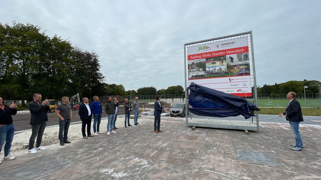Wethouder Henk Jan Schmaal onthult het bouwbord van de 'Skills Garden' bij het Leer - en Sportpark in Veendam